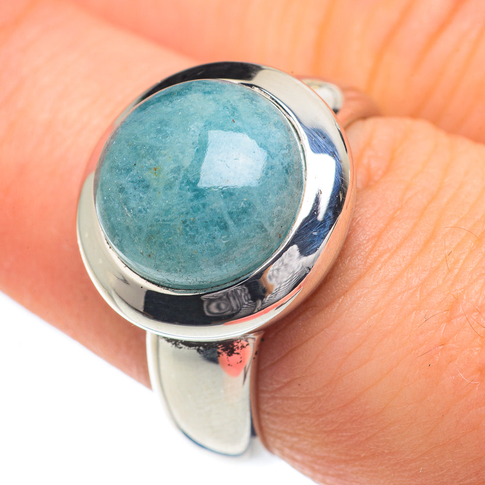 Aquamarine blue oval gemstone on polished sterling silver ring, worn on hand