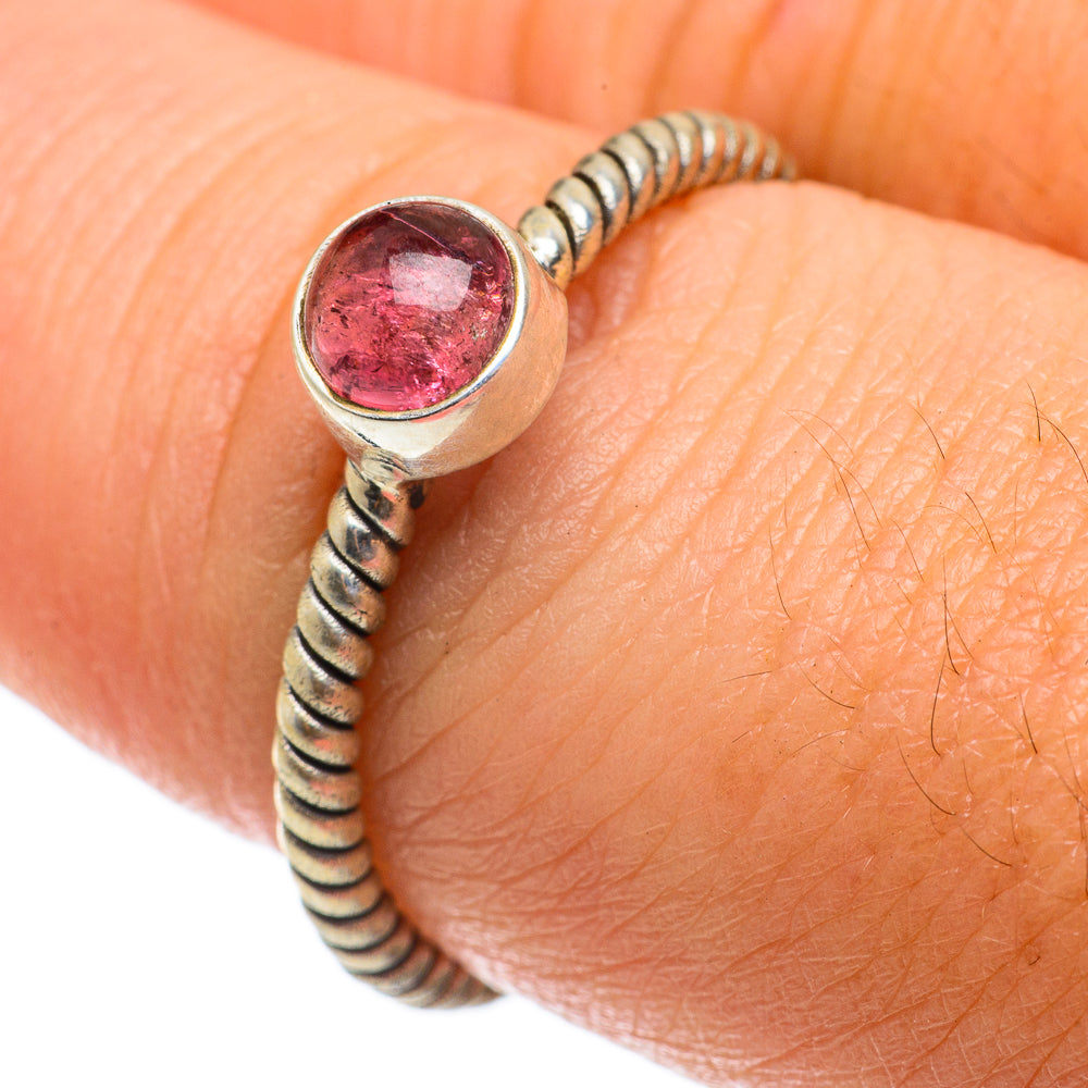Pink tourmaline ring with twisted silver bead band and round bezel gemstone, on finger