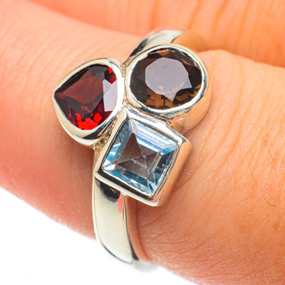 Sterling silver ring with dark red oval, dark round, and light blue square gemstone