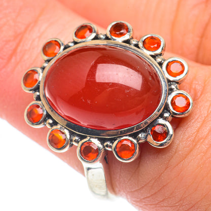 Sterling silver carnelian ring with glossy red oval stone and halo of orange accents