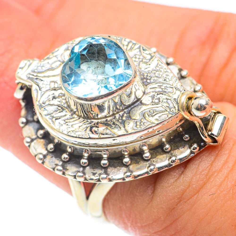 Oval blue gemstone ring with decorative silver filigree, studded band, and small clasp