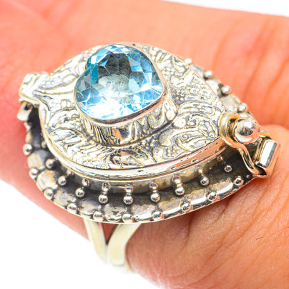 Oval blue gemstone ring with decorative silver filigree, studded band, and small clasp