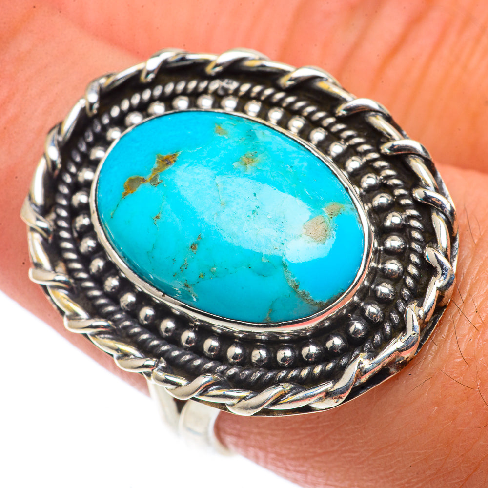 Turquoise cabochon silver ring with ornate beaded frame, oval center on finger