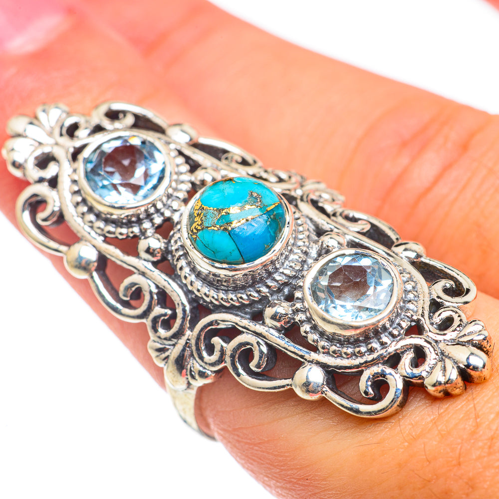 Silver-tone filigree ring with blue round stones and oval turquoise center