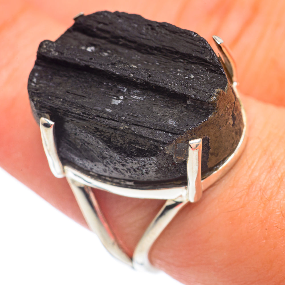 Rough black tourmaline ring on finger, silver band with open bezel prongs