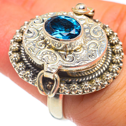 Ornate sterling silver ring with oval blue gemstone bezel and filigree top detail
