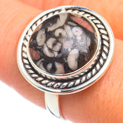 Sterling silver crinoid fossil cabochon ring with dark oval stone and ornate rope bezel