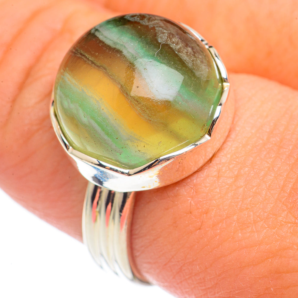 Green fluorite oval gemstone ring with polished silver bezel on finger