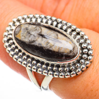 Sterling silver oval fossil ring with beaded border and dark oval stone setting