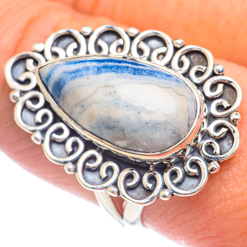 Blue teardrop gemstone ring in sterling silver, detailed filigree edge, worn on hand