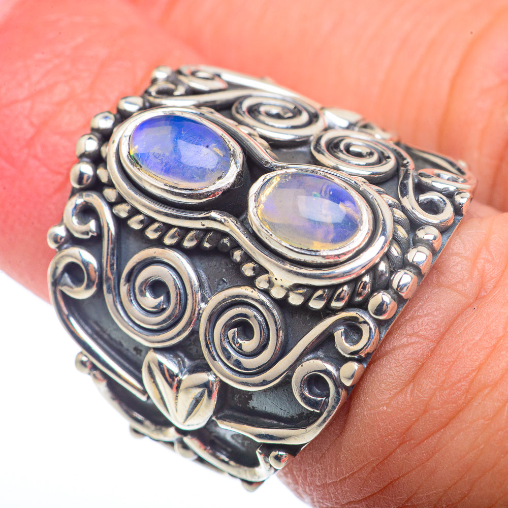 Sterling silver opal ring with two oval blue and white cabochons, ornate scroll setting