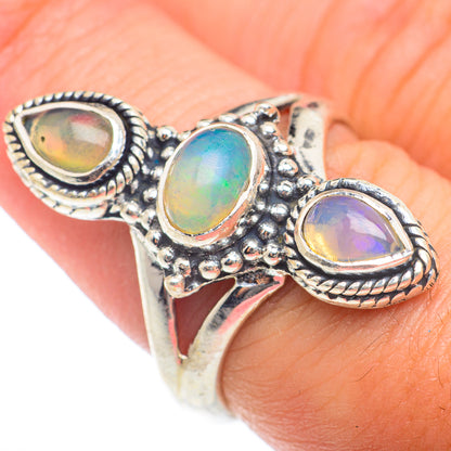 Sterling silver opal ring with three oval bezel-set stones, finger view