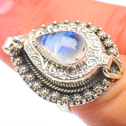 Teardrop moonstone poison ring in sterling silver with engraved details, worn on finger