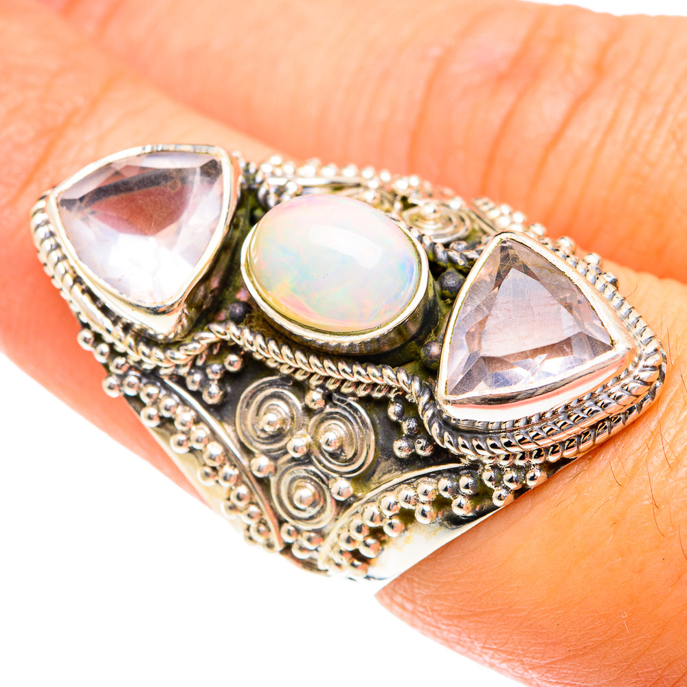 Sterling silver filigree ring with iridescent opal center and two pale triangle stones