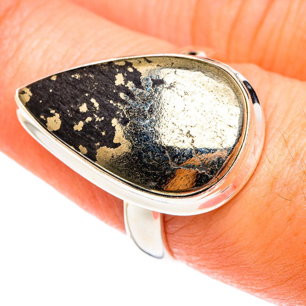 Teardrop silver ring on finger, dark onyx-style stone with gold flecks