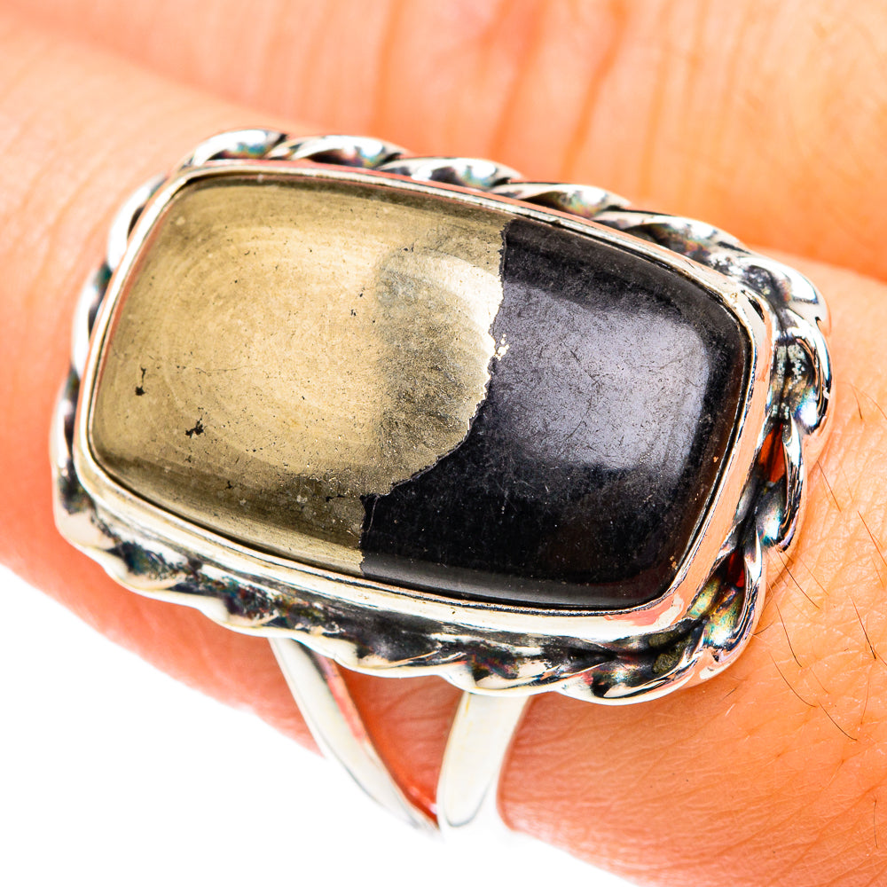 Sterling silver oval onyx ring with dark stone bezel and gold flecks along edge