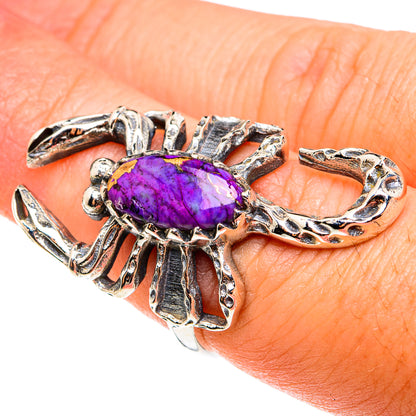 Sterling silver scorpion ring with purple oval gemstone, worn on finger