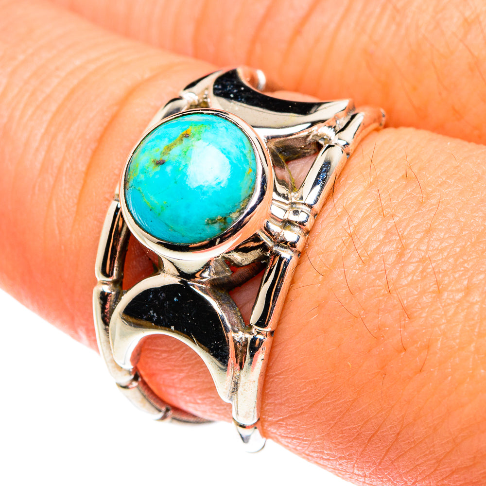 Sterling silver turquoise oval ring on finger, high-polish bezel with scrollwork details.