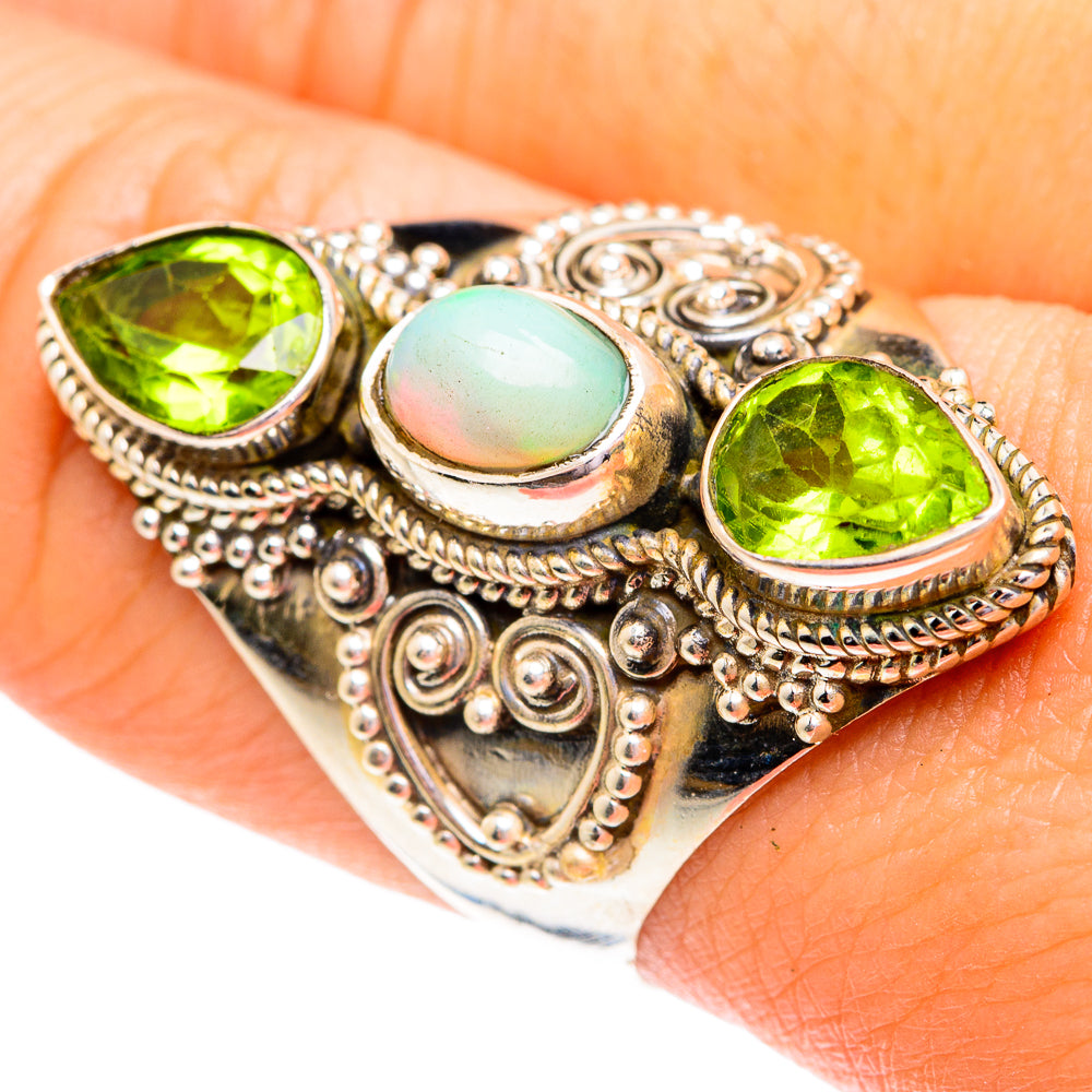 Sterling silver ring with three oval stones: two green peridots and a light opal