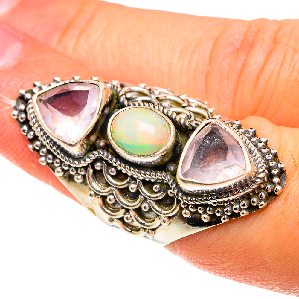 Sterling silver ring with oval opal center and two pink teardrop stones, ornate border
