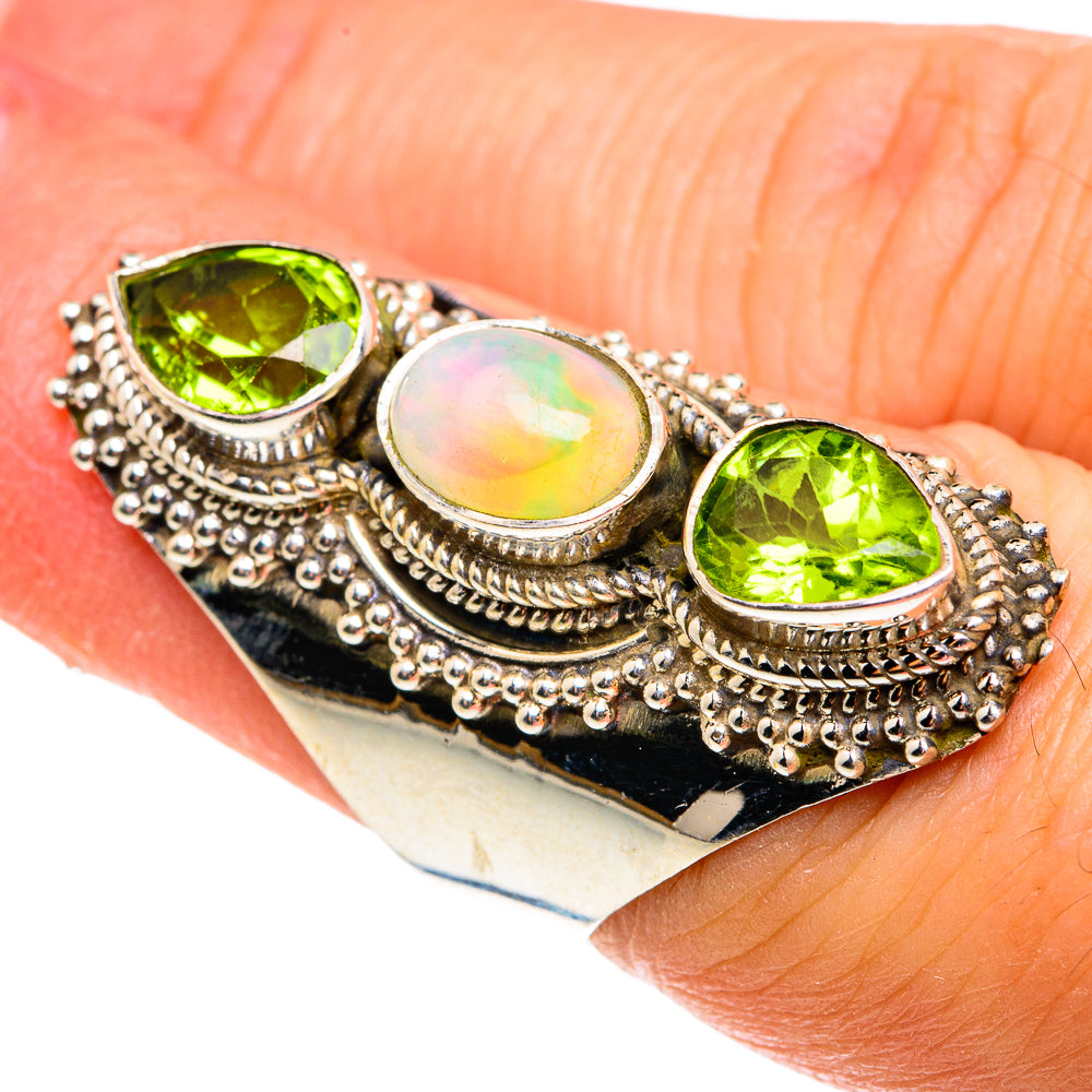 Sterling silver oval ring with green peridot side stones and iridescent opal center