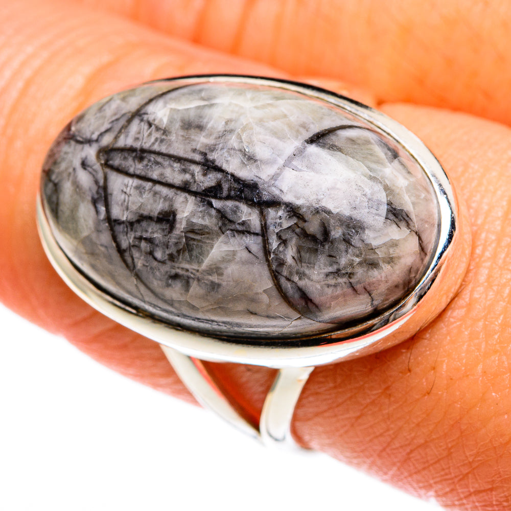 Sterling silver oval fossil ring with gray stone and black fossil pattern in bezel.