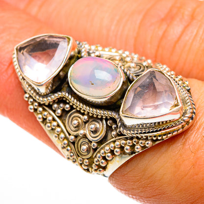 Ornate gold-tone ring with three iridescent bezel-set stones: round center and two teardrops