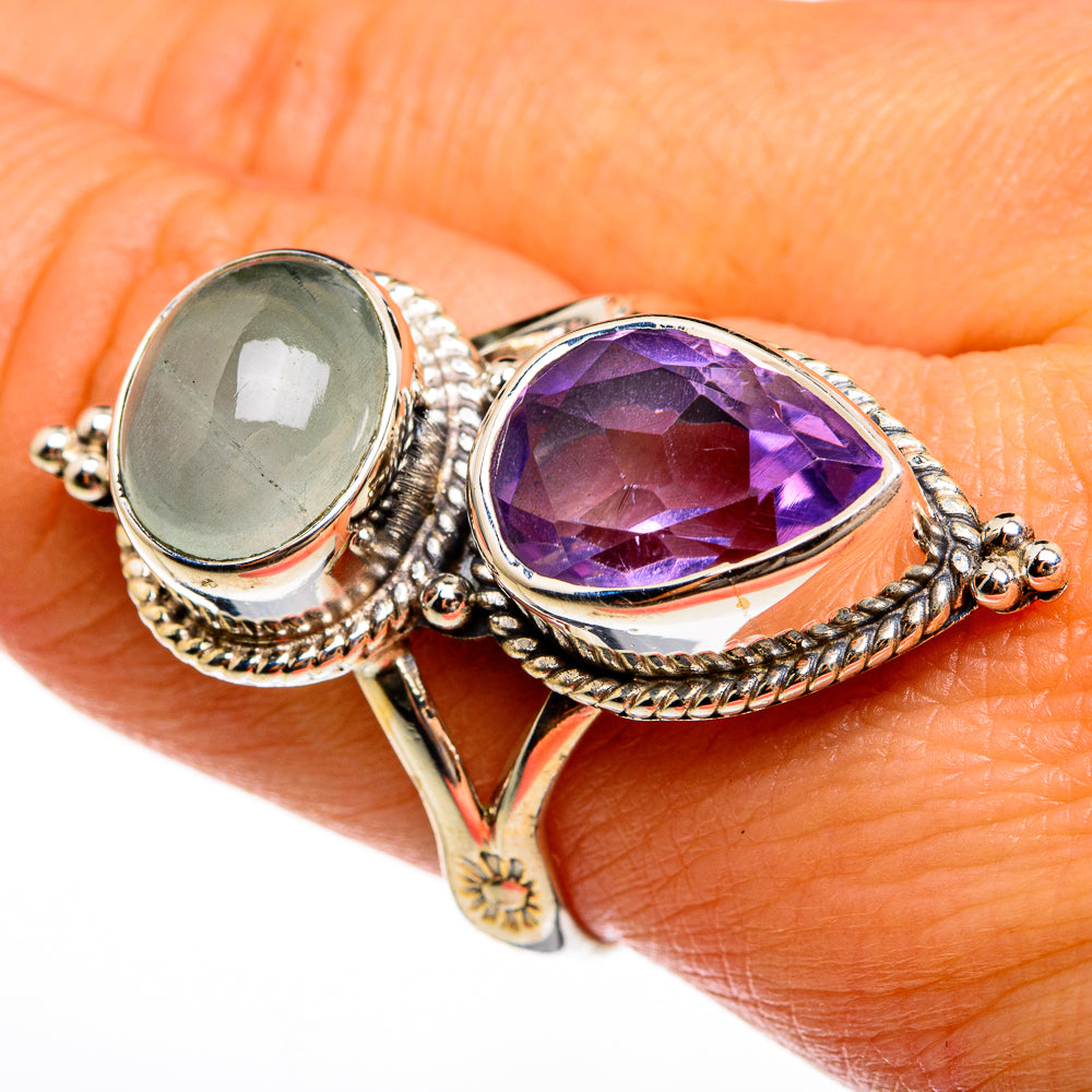 Ornate ring with oval pale green stone and faceted purple teardrop center, rope bezel