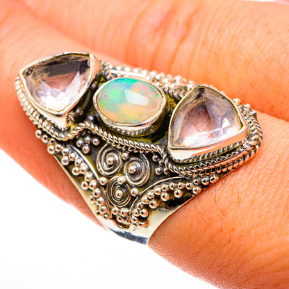 Ornate gold-tone ring with oval opal center and two pear-shaped stones, beaded filigree band
