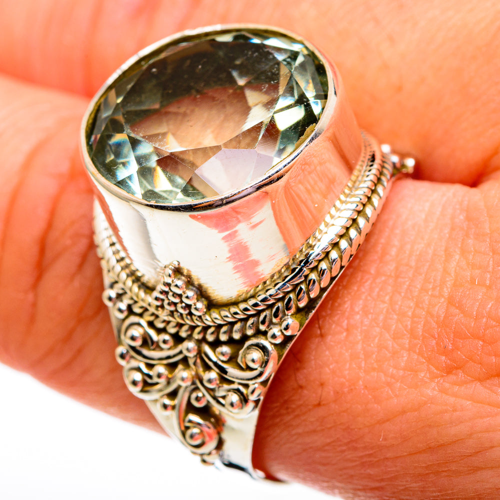 Green faceted gemstone ring with ornate filigree silver band and round bezel setting