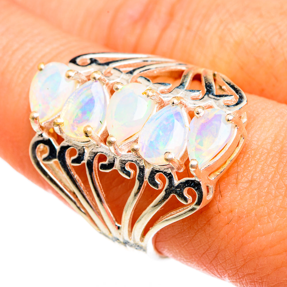 Gold-tone opal ring with three oval iridescent stones and ornate filigree setting