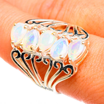 Gold-tone opal ring with three oval iridescent stones and ornate filigree setting