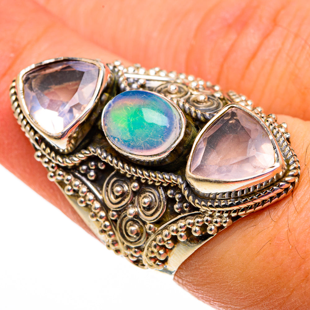 Ornate silver-tone ring with center blue-green opal and two pink teardrop stones