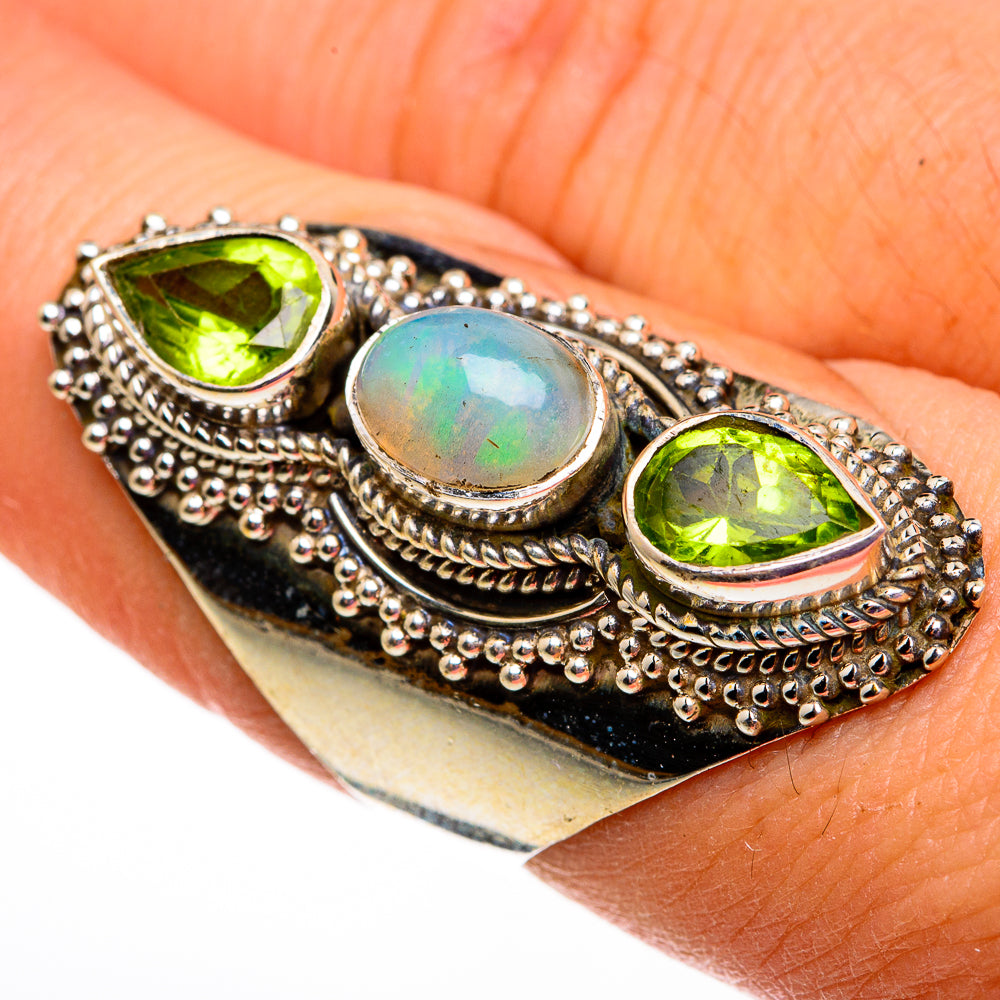Sterling silver opal and peridot ring with oval opal center and two green peridot side stones