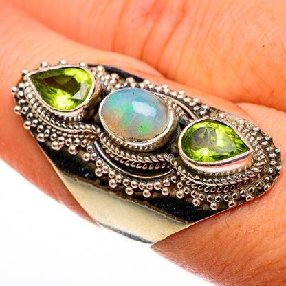 Sterling silver opal and peridot ring with oval opal center and two green peridot side stones