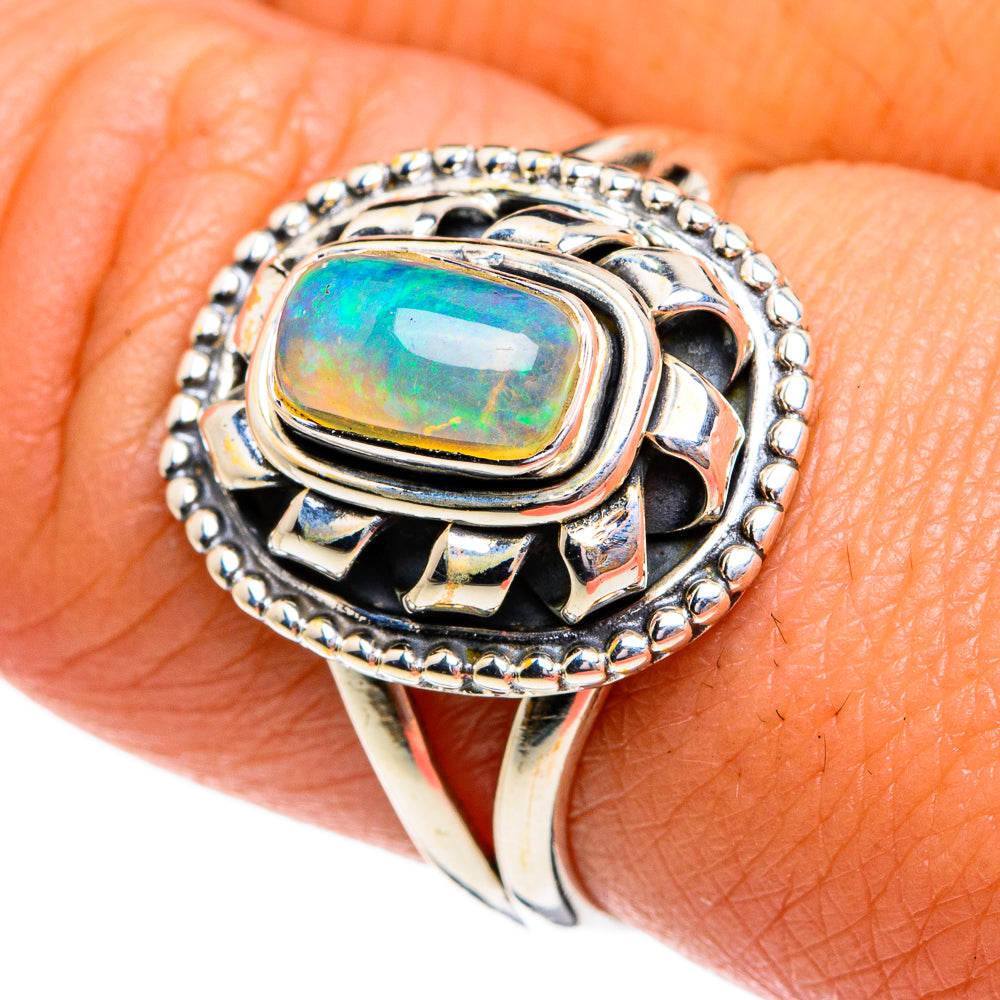 Sterling silver opal ring with oval green-blue gemstone and beaded halo setting