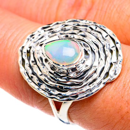 Sterling silver opal ring on finger; oval opal with colorful iridescence