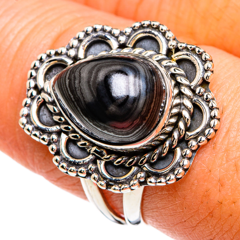 Sterling silver ring with oval dark striped stone and ornate heart-like filigree setting