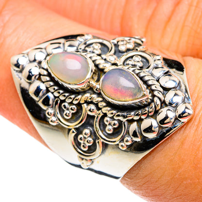Sterling silver opal ring with two oval iridescent stones and decorative scrollwork