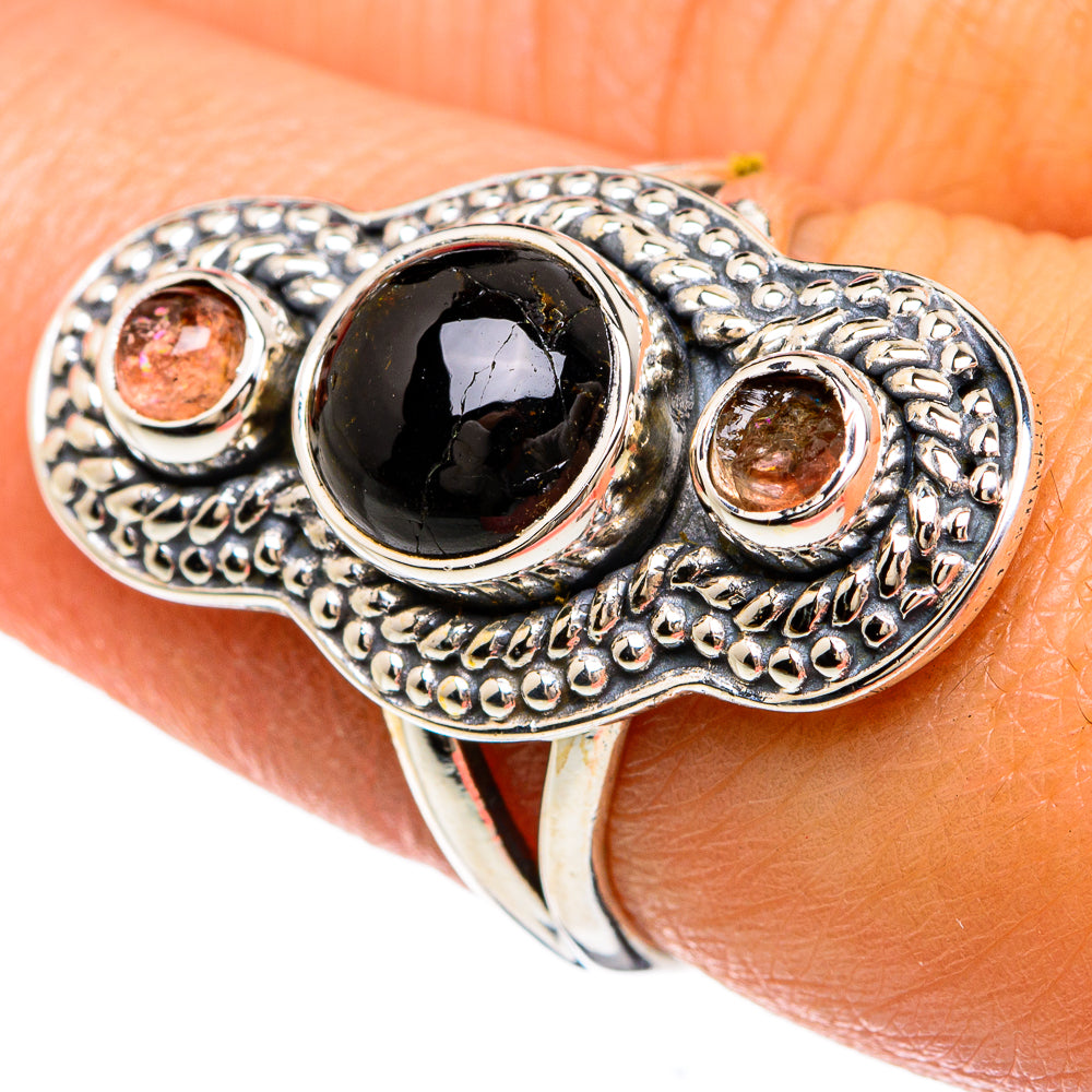 Sterling silver ring featuring dark oval onyx cabochon and two pink gemstone bezels