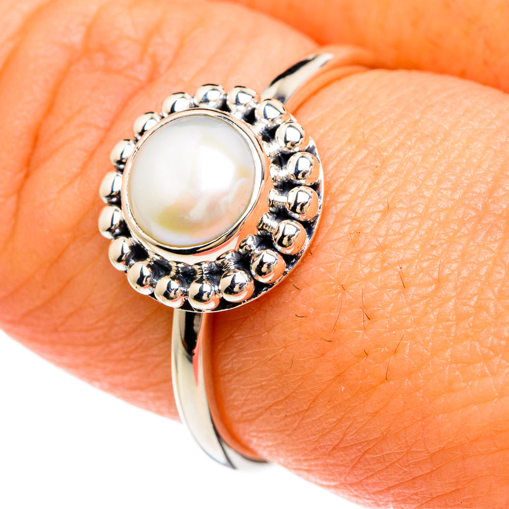 Sterling silver cultured pearl ring on hand with round pearl setting and beadwork