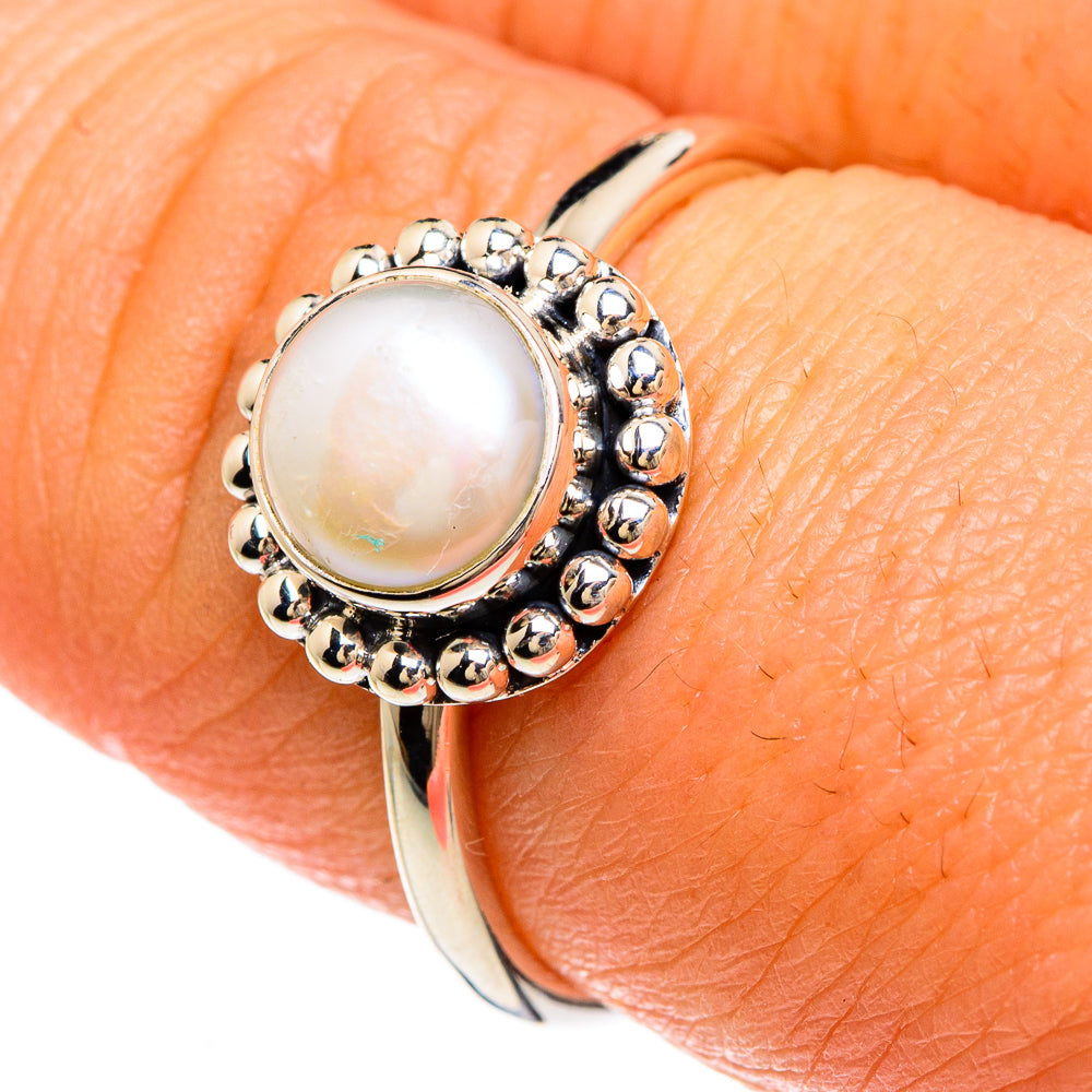 Sterling silver cultured pearl ring with round bead border on finger