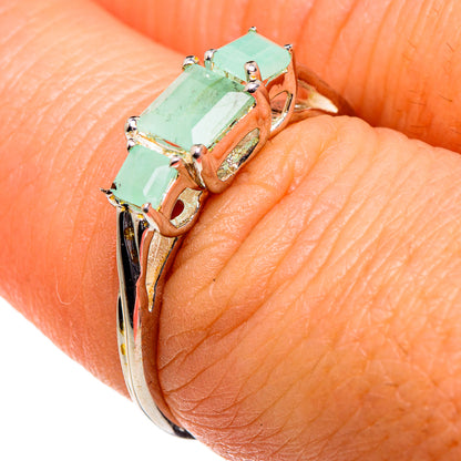 Emerald-green gemstone three-stone sterling silver ring on finger, side view