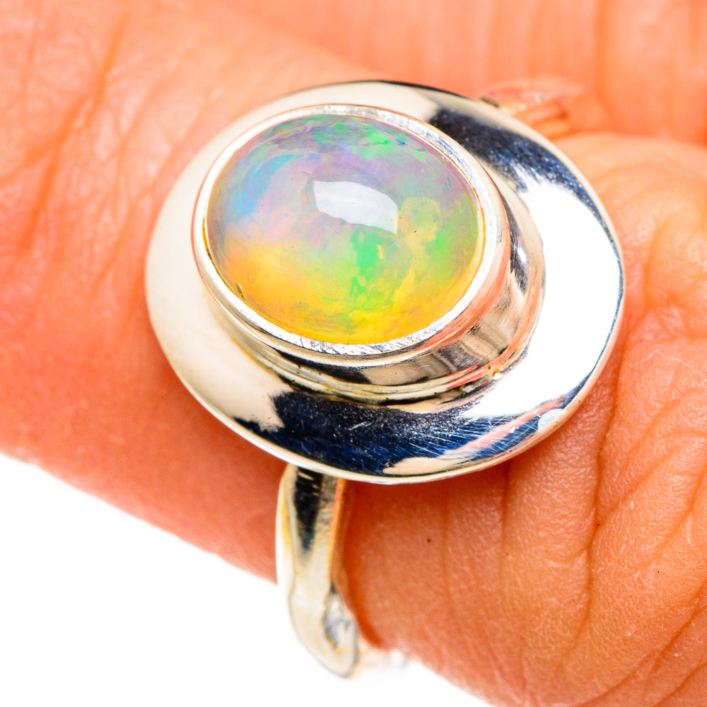 Sterling silver ring with oval natural opal cabochon, colorful rainbow glow.