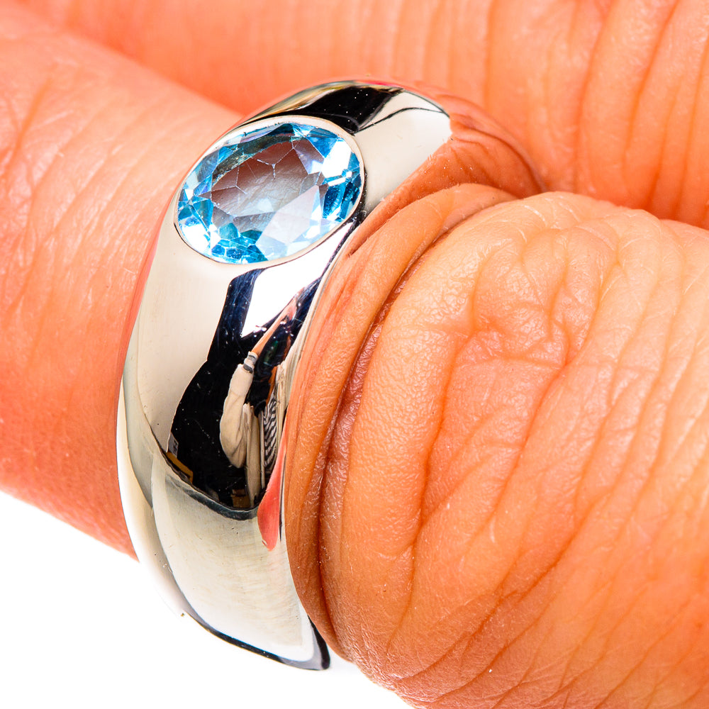 Sterling silver ring with oval blue topaz gemstone, worn on finger