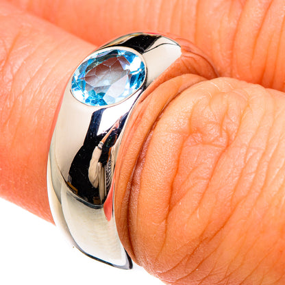 Sterling silver ring with oval blue topaz gemstone, worn on finger