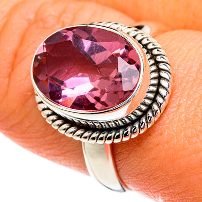 Silver ring with oval color-changing gemstone and twisted rope bezel, pink-purple stone.