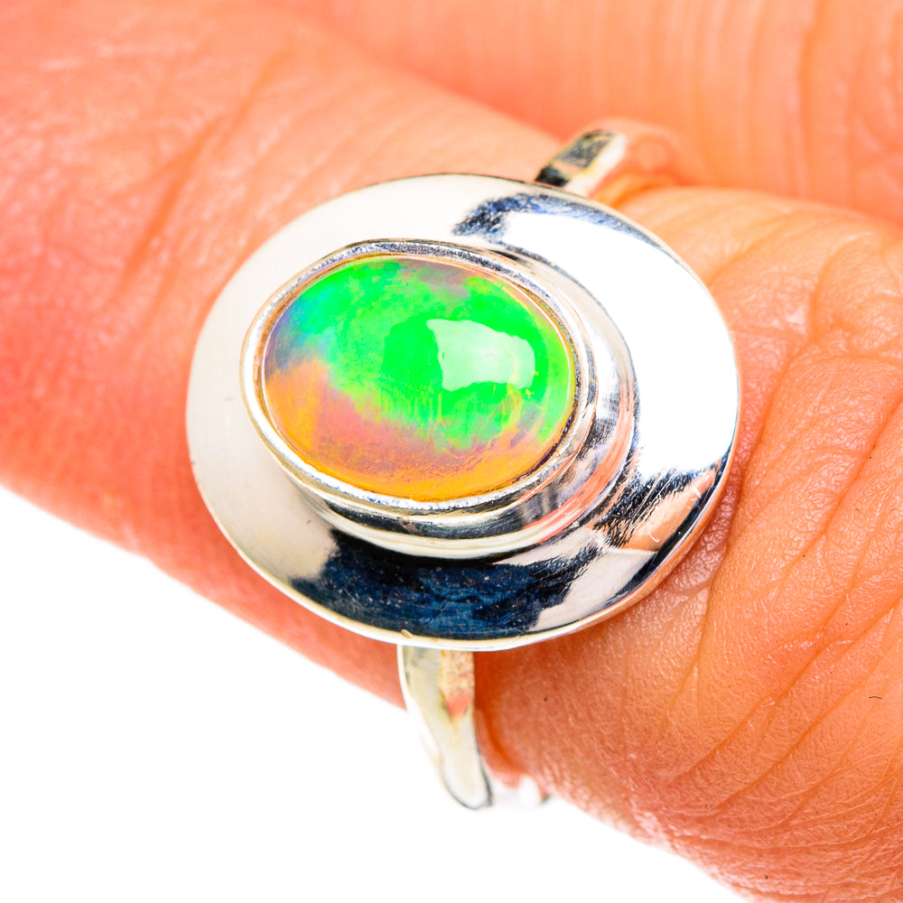 Oval opal ring with bright green and orange iridescence on polished 925 silver band