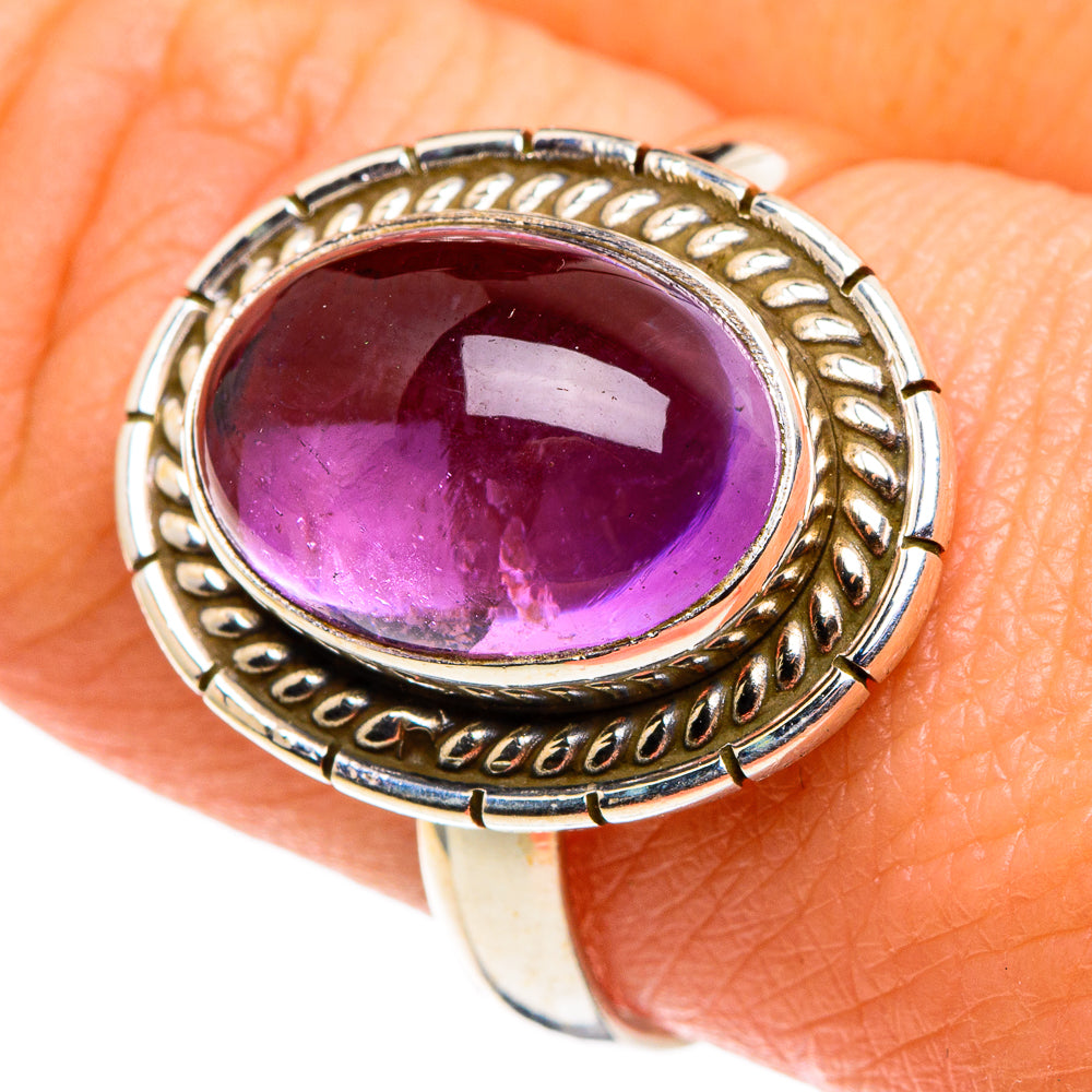 Amethyst oval cabochon ring with ornate silver bezel and purple gemstone