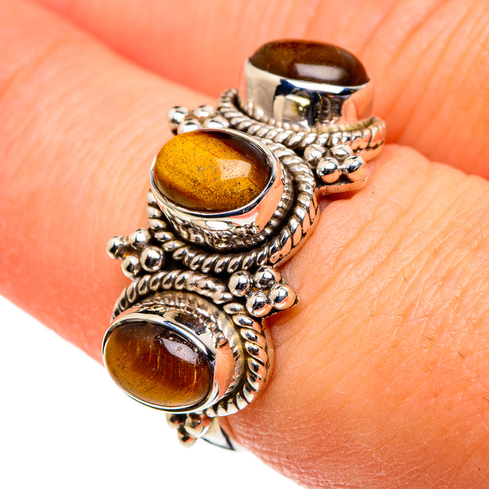 Tiger eye cabochon ring on wrist, silver rope and bead details with three amber stones